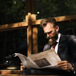 Businessman reading newspaper at coffee shop